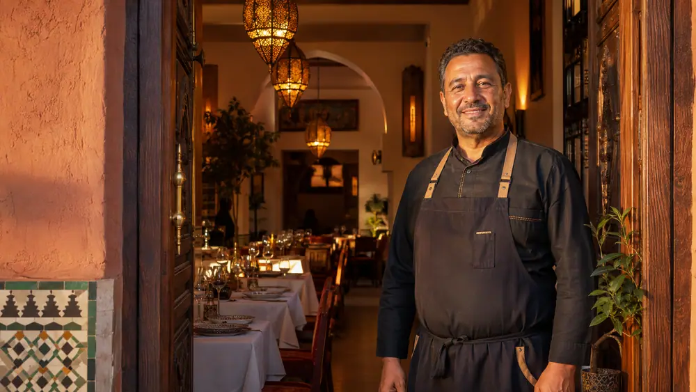 Restaurateur devant sa salle chaleureuse au Maroc